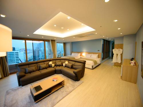 a living room with a couch and a bed at Haeundae Marianne Hotel in Busan