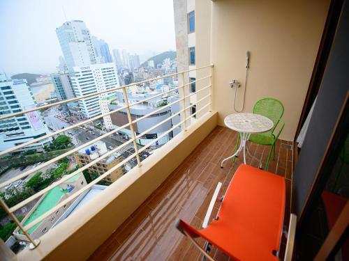 a balcony with a table and chairs and a view of a city at Haeundae Marianne Hotel in Busan