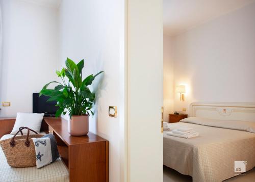 a bedroom with a bed and a potted plant at Genovese Villa Elena Residence in Varazze