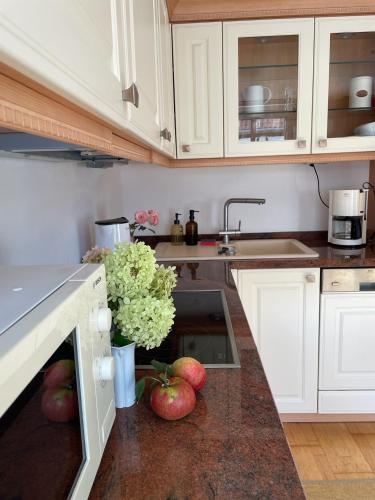 a kitchen with apples and flowers on the counter at Lichtblick Dähre in Dähre