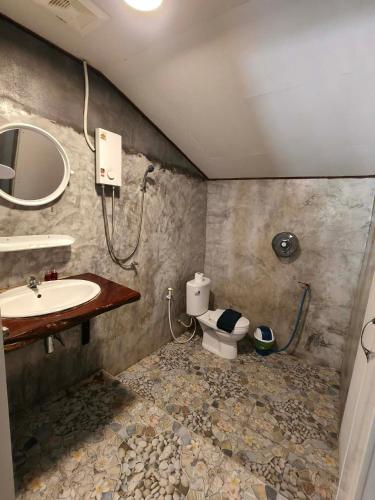 a bathroom with a toilet and a sink at Khao Sok Nung House in Khao Sok National Park