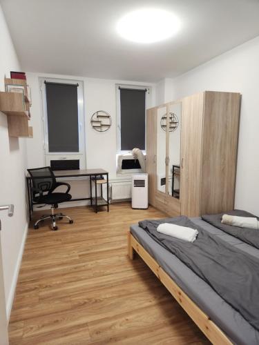 a bedroom with a bed and a desk and a chair at Cosy Place for one/two in Berlin