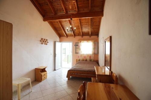 a bedroom with a bed and a table in a room at Katina Balos Rooms-Studios in Koumeika