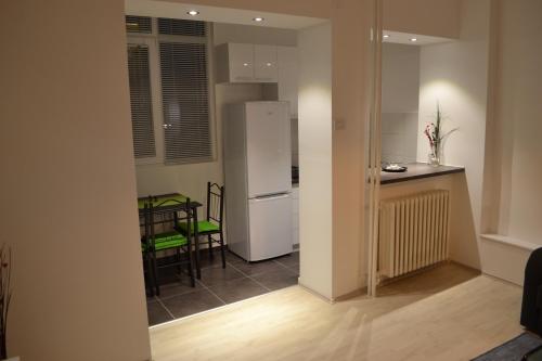 a kitchen with a white refrigerator and a table at Lazarus Apartment in Skopje