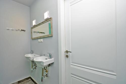 a bathroom with two sinks and a mirror at Wanderlust Guest House Prime Location in Yerevan