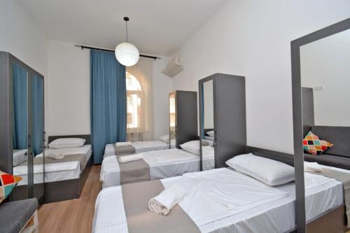 a row of beds in a room with mirrors at Wanderlust Guest House Prime Location in Yerevan