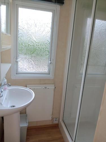 a bathroom with a sink and a window at 't Kotje Ouddorp in Ouddorp