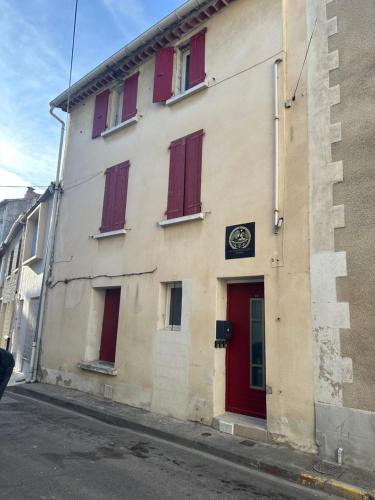 a building with red doors and windows on a street at Suite Romantique in Narbonne