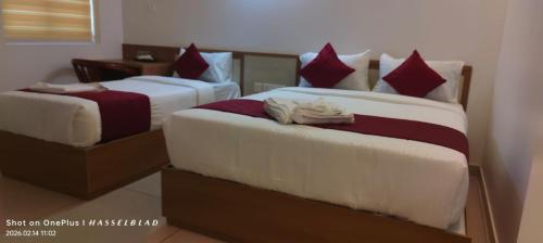 two beds sitting next to each other in a room at Hotel Eden Palace in Trichūr