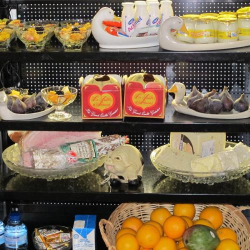 une étagère remplie de assiettes de nourriture et de fruits dans l'établissement Hotel Le Meurice, à Nice