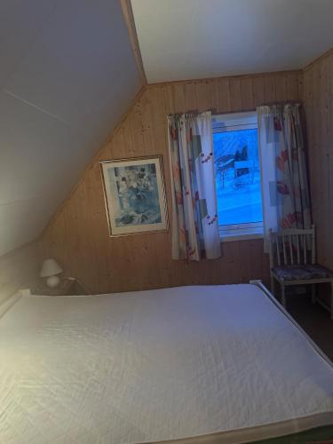 a bedroom with a large white bed and a window at Holiday home for rent in Lyngen