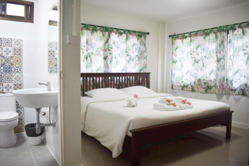 a bedroom with a bed and a sink and curtains at Seapine Beach Golf and Resort Hua Hin in Hua Hin