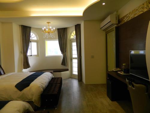 a bedroom with a bed and a tv and a window at Dream Ocean View B&B in Magong