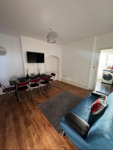 a living room with a blue couch and a table at London House near Greenwich, Free Parking, Free WIFI in London
