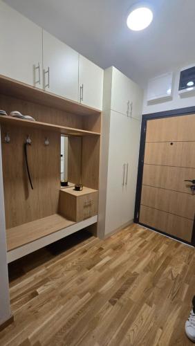 an empty room with a kitchen with a wooden floor at Apartman Simić in Smederevo
