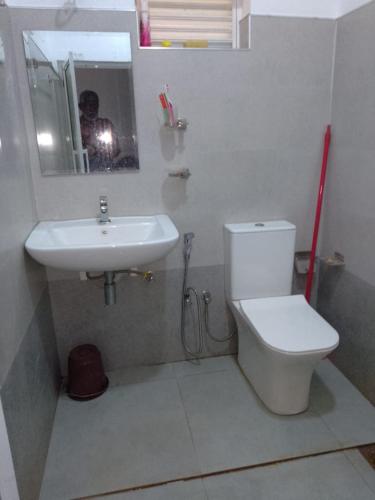 a bathroom with a sink and a toilet and a mirror at Uswatta in Matara