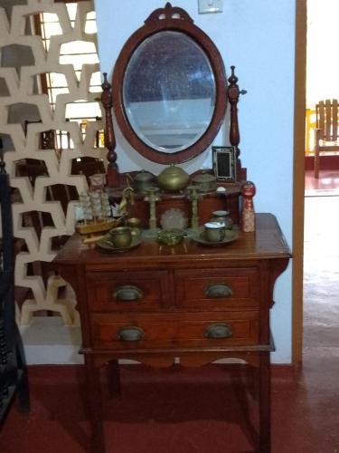 a wooden dresser with a mirror on top of it at Uswatta in Matara
