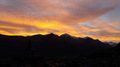 a sunset over a city with mountains in the background at Les Rochers in Saint-Savin