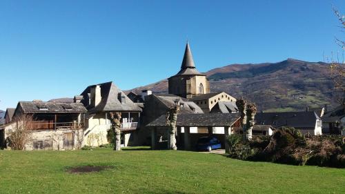 an old house with a church in a field at Les Rochers in Saint-Savin