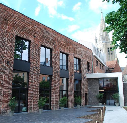a brick building with windows on the side of it at Albion Hotel in Ieper
