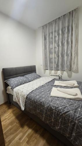 a bedroom with a bed and a window at Apartman Simić in Smederevo