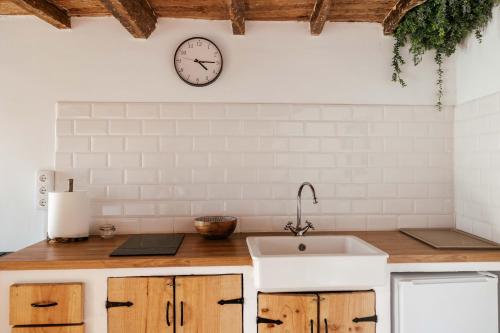 a kitchen with a sink and a clock on the wall at El rinconin del Sueve in San Martín