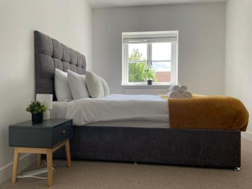 a bedroom with a large bed and a window at Exclusive 1 and 2 Bedroom Flats only 0,5 miles aw in Bicester