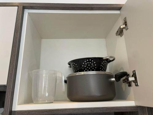 a cabinet with a pot and other kitchen utensils at Exclusive 1 and 2 Bedroom Flats only 0,5 miles aw in Bicester