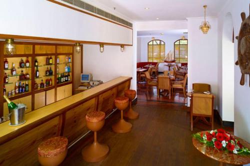 a restaurant with a bar and a dining room at The Mascot Hotel - A Heritage Living Experience in Trivandrum