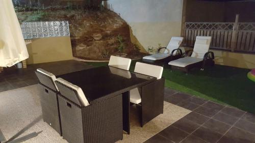 a patio with chairs and a table and a yard at Casa Miradouro do Moinho in Porto Santo