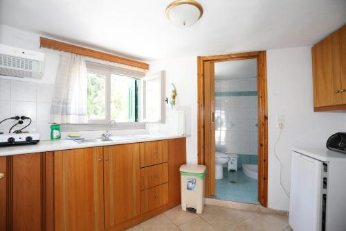 a kitchen with a sink and a toilet and a window at Katina Balos Rooms-Studios in Koumeika