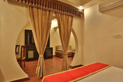 a bedroom with a bed and a living room at Hotel The Grand Chandiram in Kota