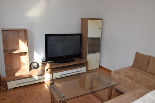 a living room with a flat screen tv on a table at Maisonette im Hof Krupp in Bruchhausen