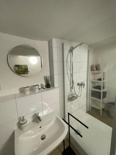 a white bathroom with a shower and a sink at Fachwerk Rustikal in Melsungen