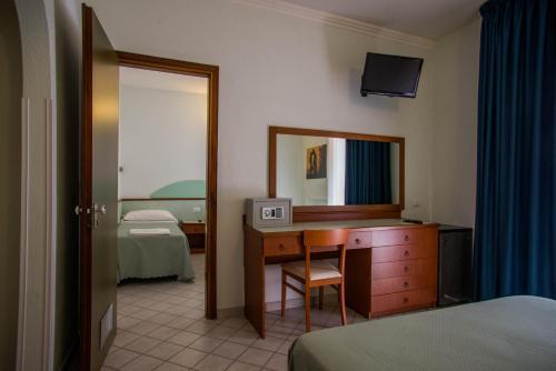 una camera d'albergo con scrivania e specchio di Hotel Gli Ulivi a Soverato Marina