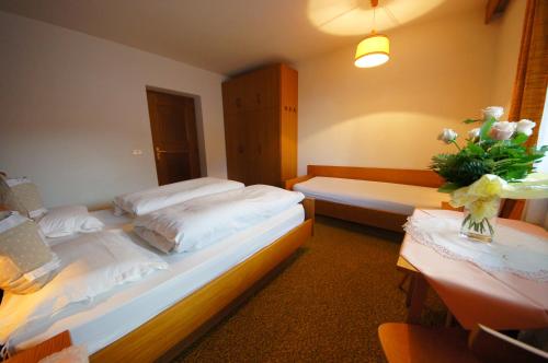 a bedroom with two beds and a vase of flowers at Ciasa Complojer in La Valle