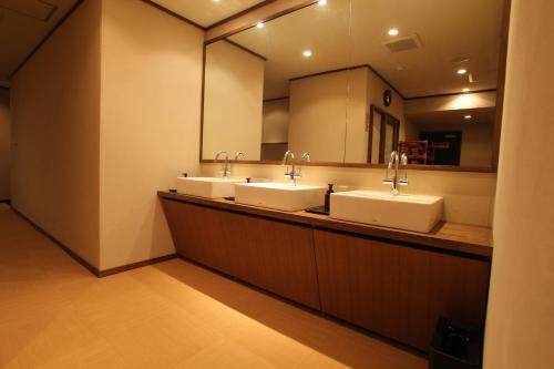 a bathroom with three sinks and a large mirror at 大同 Garden Hotel 湯の山リゾート in Komono