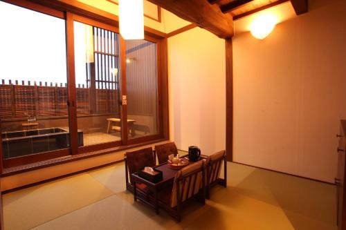 a room with a table and a large window at 大同 Garden Hotel 湯の山リゾート in Komono