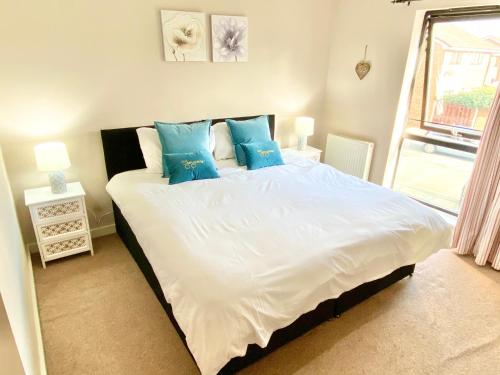 a bedroom with a large white bed with blue pillows at Spacious 5 bed townhouse Manchester, Salford Qauys - Two Bedroom with Parking in Manchester