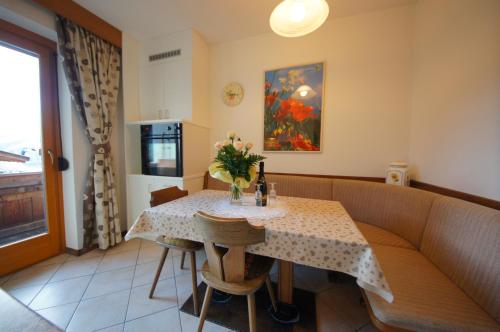 a dining room with a table with flowers on it at Ciasa Complojer in La Valle