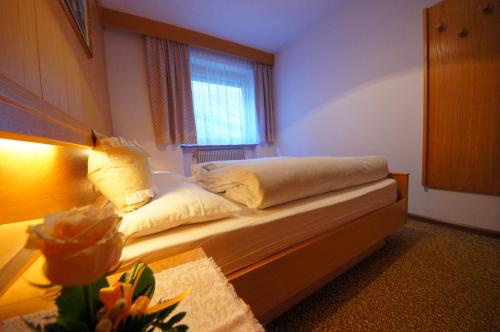 a bedroom with a bed with a window and a table at Ciasa Complojer in La Valle