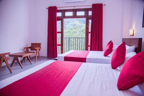 a bedroom with two beds with red pillows and a window at Scenic View - Ella in Ella