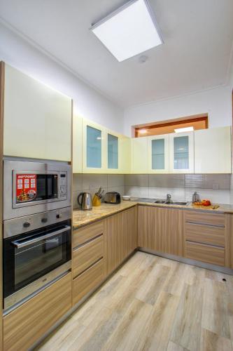 a kitchen with wooden cabinets and stainless steel appliances at Executive Residency by Best Western Nairobi in Nairobi