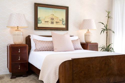 a bedroom with a bed with two lamps and a picture at Poseidon Guest House in Hout Bay