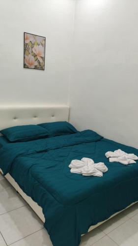 a bed with blue sheets and white towels on it at NJAZ Homestay Perlis in Arau