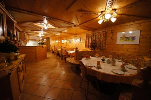 a restaurant with tables and chairs in a room at Ciasa Complojer in La Valle