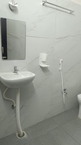 a bathroom with a sink and a mirror and a toilet at HoTEL JAGAPATHI INTERNATIONAL in Vijayawāda