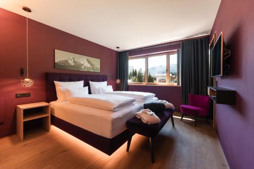 a bedroom with a large bed and a purple wall at Chalet Hohe Welt - luxury apartments in Lech am Arlberg