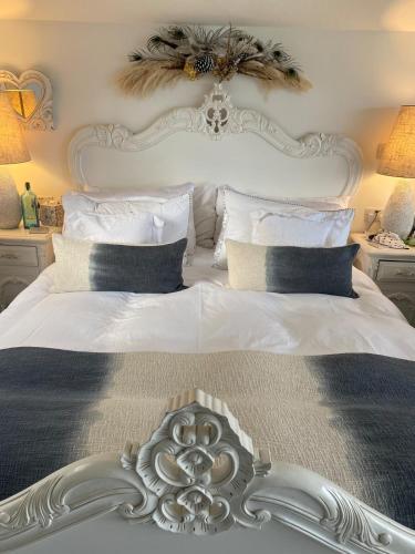a white bed with a white headboard and pillows at West mouse view in Holyhead