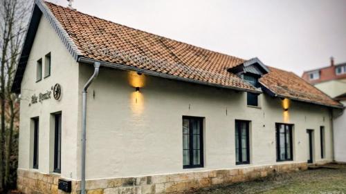a white building with a brown roof at Alte Remise Blankenburg in Blankenburg